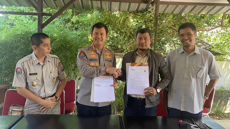 Kombespol Satake Bayu dan Pemimpin Redaksi Rakyat Sumbar, Sukri Umar melihatkan  perjanjian kerjasama.