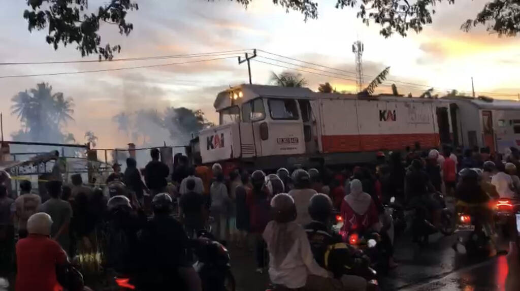 Kereta api melintas di lokasi kebakaran.