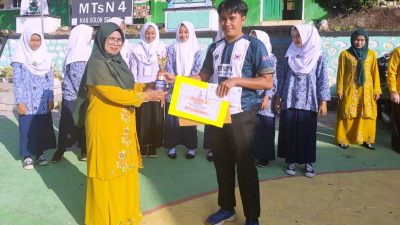 Kepala MTsN 4 Solok Selatan Fatimah, S.Pd menyerahkan hadiah kepada Guru berprestasi.