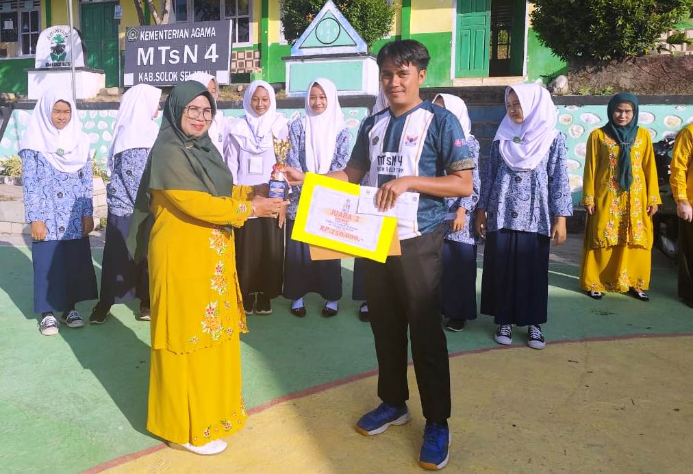 Kepala MTsN 4 Solok Selatan Fatimah, S.Pd menyerahkan hadiah kepada Guru berprestasi.