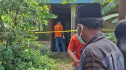 Petugas disaksikan warga memeriksa rumah ditemukan Lansia yang telah meninggal dunia dalam keadaan membusuk, Minggu (13/07/2025).