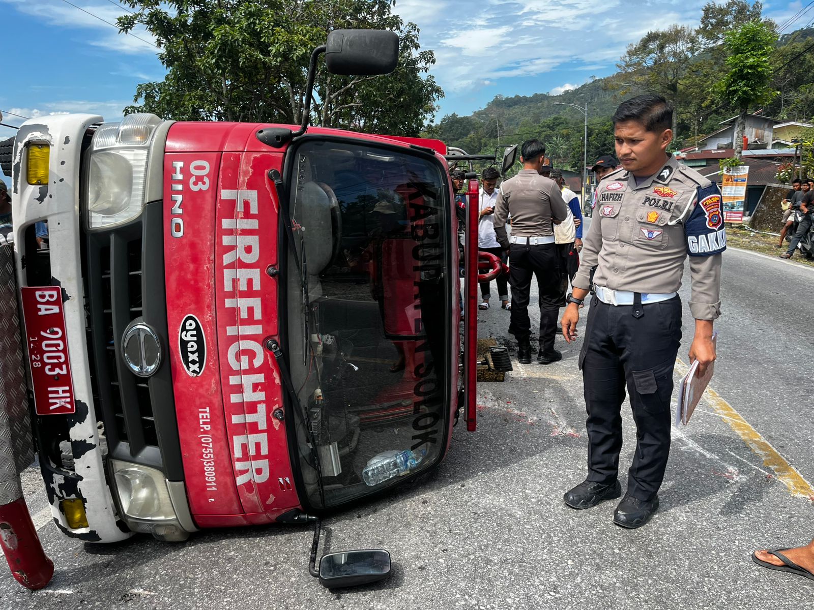 Petugas Polres Solok saat mendatangi lokasi Mobil Damkar Kabupaten Solok yang mengalami kecelakaan di Nagari Kota Gaek Guguak, Kecamatan Gunung Talang, Rabu (16/07/2025).   