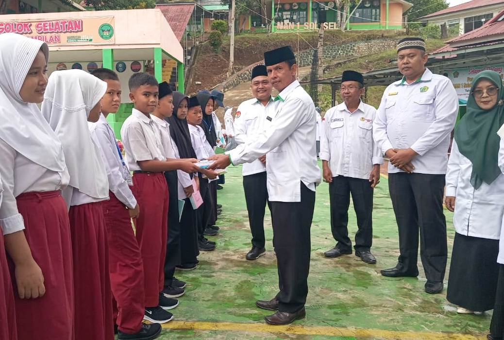 Kepala MTsN 1 Solok Selatan Nusa Jaya, M.Pd saat penyerahan bantuan buku tulis Program Berkapla di MAN 1 Solok Selatan.