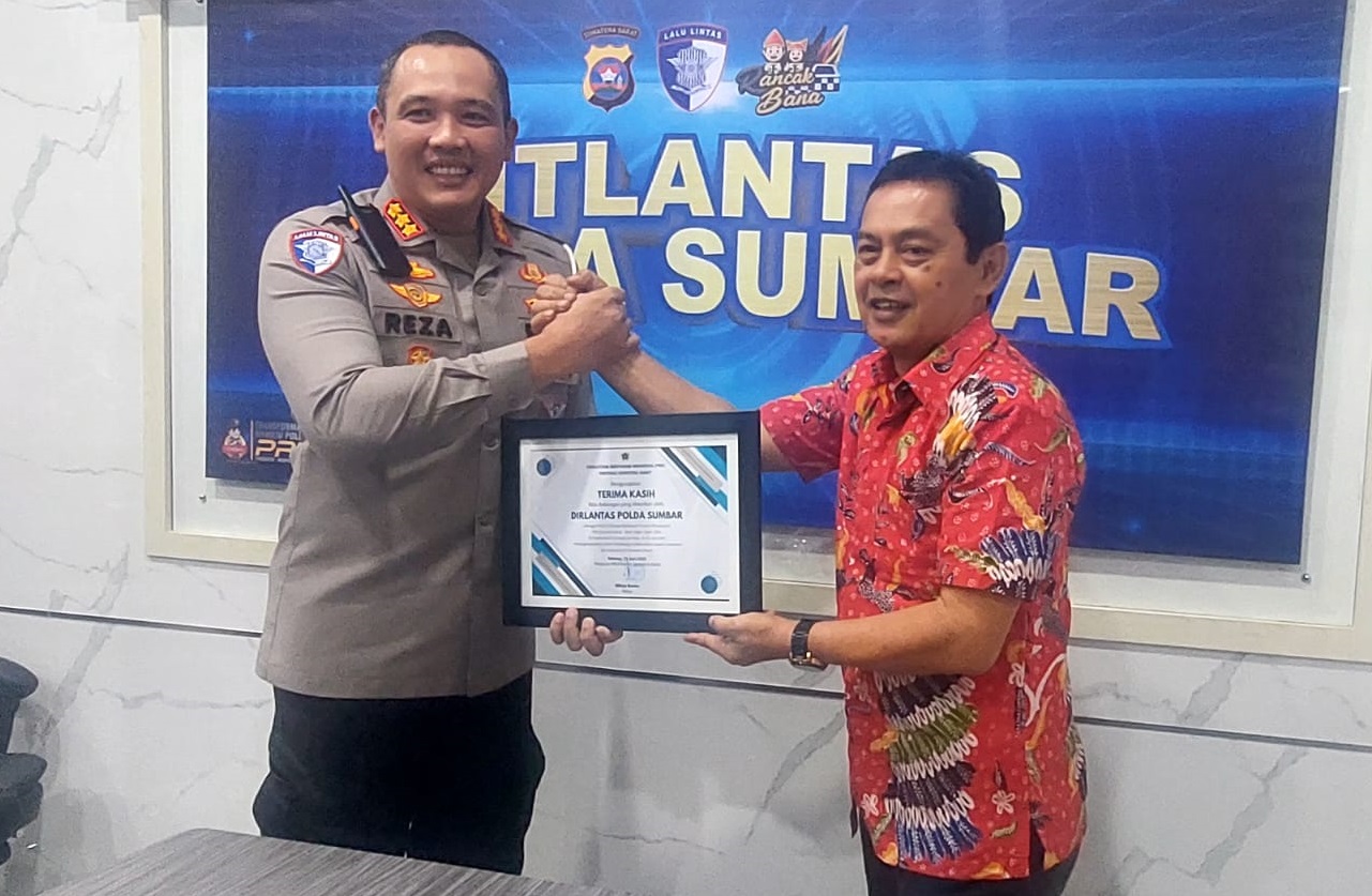 Ketua PWI Sumbar Widya Navies menyerahkan piagam penghargaan kepada Direktur Lalu Lintas Polda Sumbar, Kombes Pol H. M. Reza Chairul Akbar Sidiq.