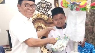 Tokoh masyarakat Nagari Pulakek Koto Baru Drs Putra Nusa, MM saat menyerahkan hadiah kepada peserta Maarak Bungo Lamang terbaik Ikhsan.
