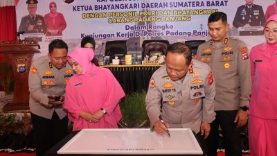 Kapolda Sumbar Irjen.Pol. Dr. Drs. Gatot Tri Suryanta, M.Si., CSFA., bersama Ketua Bhayangkari Daerah Sumbar Ny. Sari Gatot Suryanta, saat menuliskan kesan dalam kunjungan kerja ke Polres Padangpanjang.