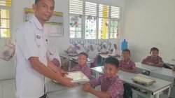 Kepala UPT SDN 04 Bariang Rao-rao,Kecamatan Sungai Pagu Kabupaten Solok Selatan Asbandi, S.Pd, M.Pd saat ikut mendistribusikan MBG kepada siswa.