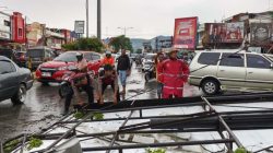 Petugas BPBD bersama Pihak Kepolisian terlihat membersihkan material papan reklame dan pohon yang tumbang di Pusat Kota Solok.