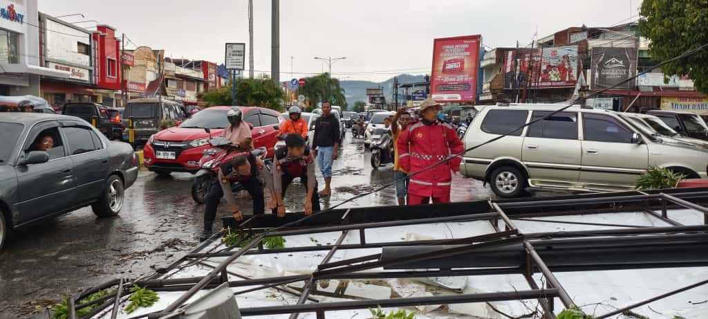 Petugas BPBD bersama Pihak Kepolisian terlihat membersihkan material papan reklame dan pohon yang tumbang di Pusat Kota Solok.