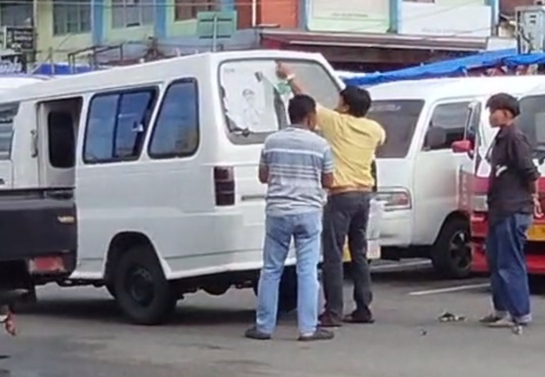 Sopir Angkot mencopot stiker Angkutan Pelajar Gratis yang terpasang di kaca belakang Angkot.