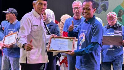 Kepala Dinas Pendidikan dan Kebudayaan Kota Padangpanjang Nasrul saat menyerahkan penghargaan kepada penyanyi dan pencipta lagu Album Anak PAUD, Rabu (26/11/2025).