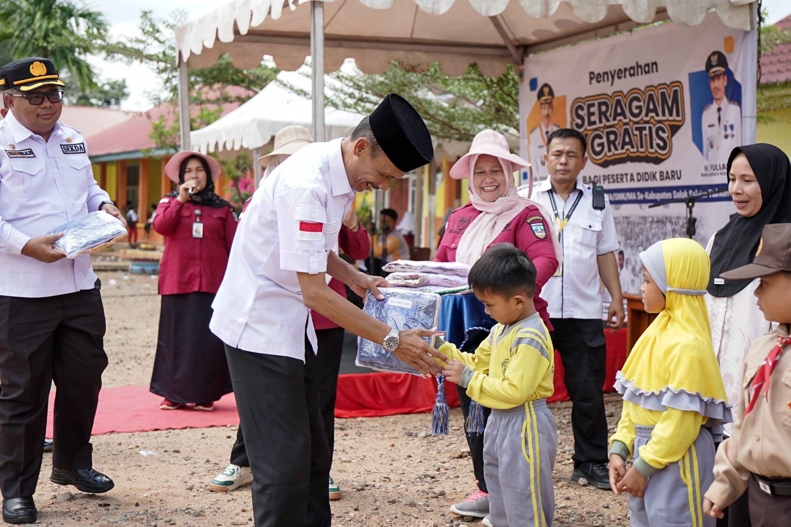 Wakil Bupati Solok Selatan Yulian Efi saat menyerahkan baju seragam sekolah gratis kepada siswa di Sangir Batang Hari, Rabu (03/12/2025).