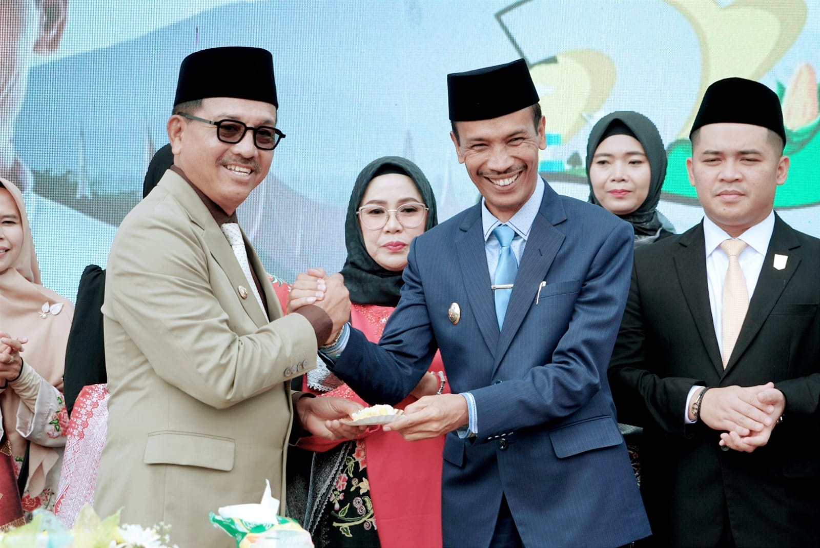 Bupati Solok Selatan H Khairunas menyerahkan potongan kue HUT Solok Selatan kepada Wakil Bupati H. Yulian Efi