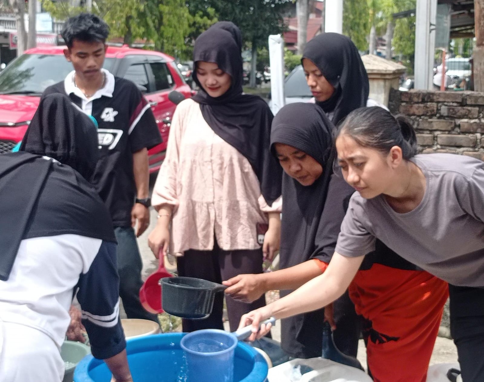 Petugas BPBD membagikan air bersih di Pasar Ambacang, Kecamatan Pauh.