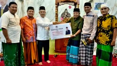 Anggota DPRD Padang Erianto saat menyerahkan bantuan kepada pengurus Masjid Nurul Falah Sungai Sapih