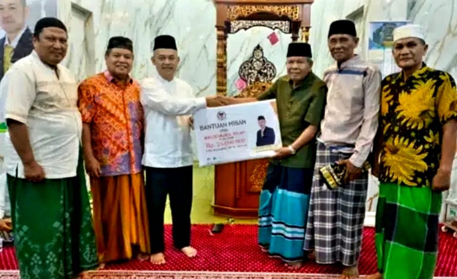 Anggota DPRD Padang Erianto saat menyerahkan bantuan kepada pengurus Masjid Nurul Falah Sungai Sapih