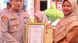 Kapolres Pasaman Barat AKBP. Agung Tribawanto menyerahkan penghargaan kepada guru berprestasi dan penanaman pohon di SDN 16 Pasaman, Selasa (05/05/2026).