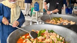 Penuangan bahan baku utama ke dalam kuali oleh Komisaris PT Gadih Minang Anugerah Drs. Syahruddin dan Dra. Anwida pada Masak Besar Rendang Gadih, Jum’at (15/05/2026).