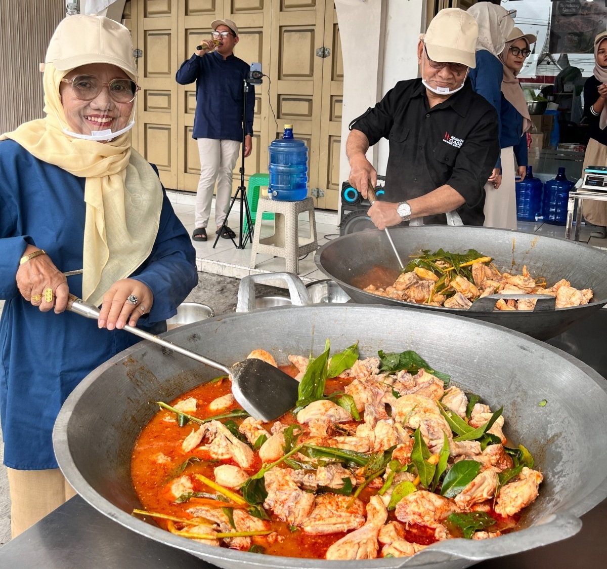 Penuangan bahan baku utama ke dalam kuali oleh Komisaris PT Gadih Minang Anugerah Drs. Syahruddin dan Dra. Anwida pada Masak Besar Rendang Gadih, Jum’at (15/05/2026).