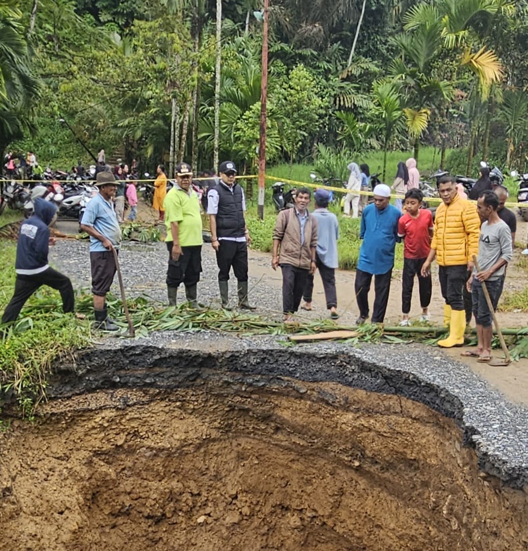 Akses jalan kabupaten ruas Ladang Laweh-Batas Batusangkar yang ditimbun tanah longsor, sudah dibersihkan warga dengan gotong royong, dibantu mobil penggelontor air milik Dinas Damkar.