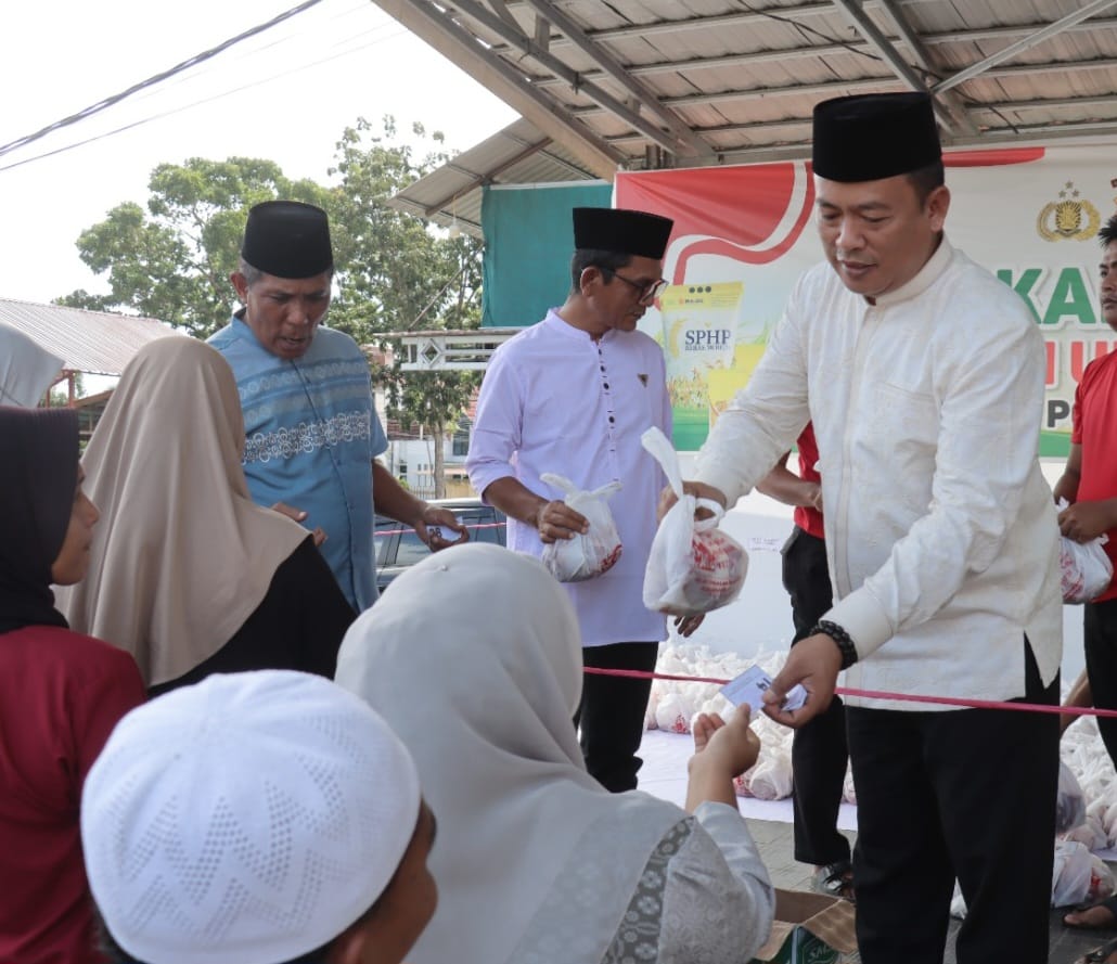 Kapolres Pasaman Barat AKBP Agung Tribawanto, S.IK saat menyerahkan daging kurban kepada masyarakat di halaman Mapolres Pasaman Barat, Rabu (27/05/2026).