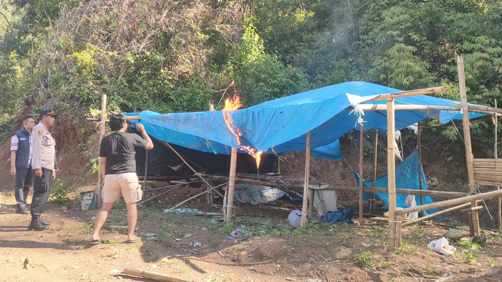 Petugas membakar tenda yang digunakan pelaku PETI saat razia di kawasan Sungai Durian dan Bukit Bais, Kecamatan IX Koto Sungai Lasi, Kabupaten Solok.