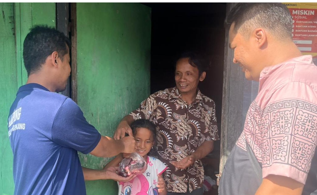 Salah seorang WBP Rutan Padangpanjang didampingi petugas saat menyerahkan daging kurban kepada masyarakat di sekitar Rutan Kelas IIB Padangpanjang, Rabu (27/05/2026).