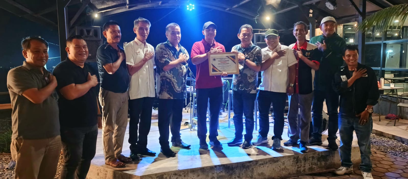 Ketua PWI Sumbar Widya Navies menyerahkan penghargaan kepada Kapolres Limapuluh Kota Syaiful Wachid di kawasan wisata Palano Hill, Jumat (17/07/2026) malam.