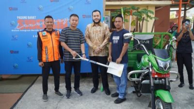Anggota DPRD Kota Padang Iswanto Kwara saat menyerahkan bantuan melalui dana Pokir berupa lima unit bentor pengangkut sampah beserta perlengkapan kebersihan lainnya, di halaman Kantor Lurah Berok Nipah, Sabtu (01/08/2026).