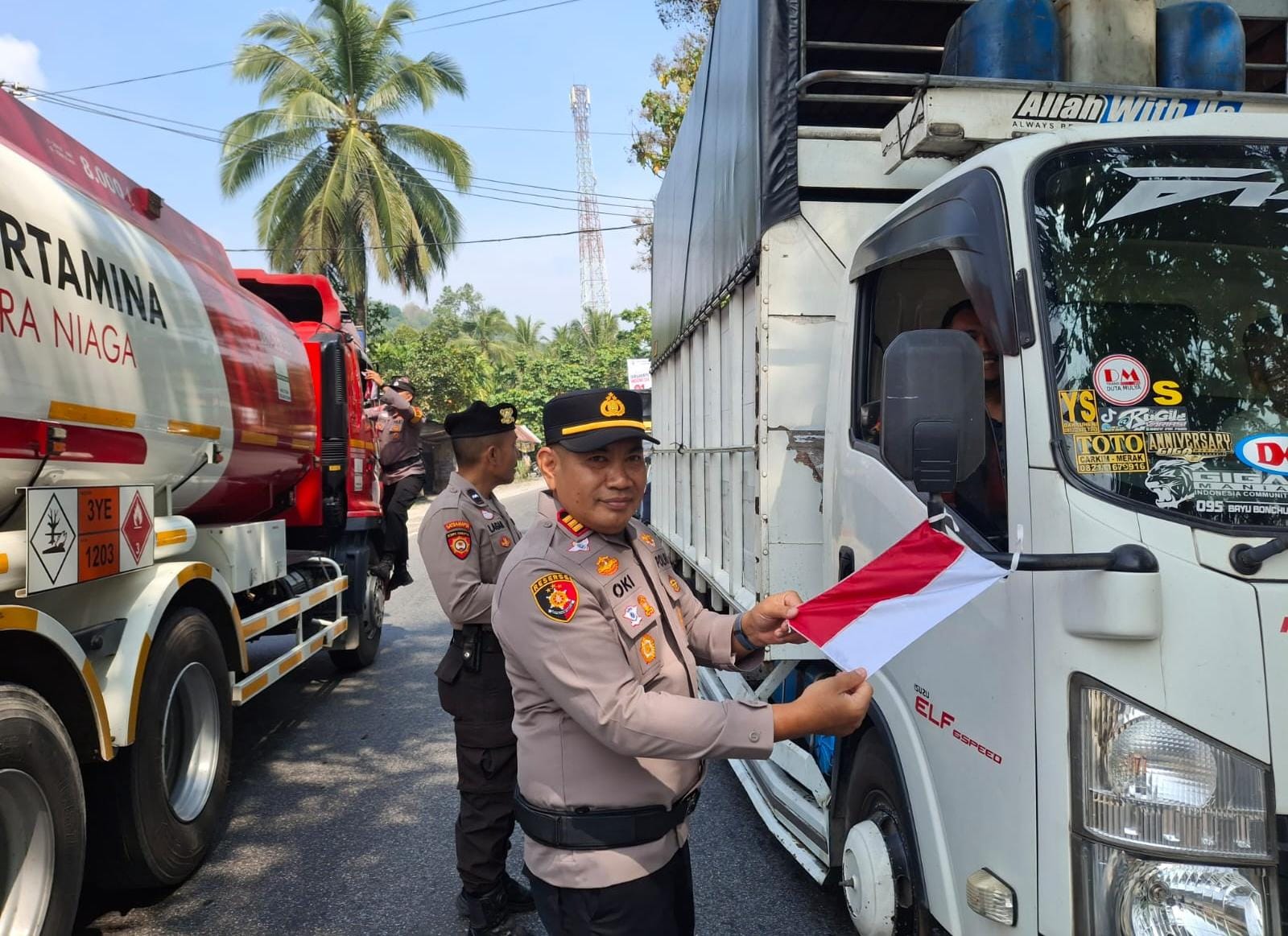 Kapolsek IX Koto Sungai Lasi membagikan bendera merah putih kepada pengunjung jalan dan masyarakat.