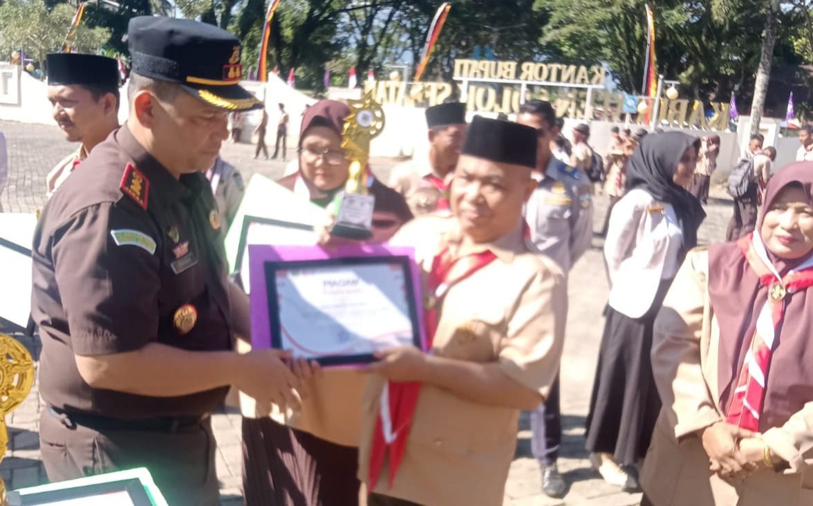 Kajari Solok Selatan Dahnir, S.H, M.H menyerahkan Piagam Penghargaan kepada Kepala MAN 1 Solok Selatan H. Jasrul, S.Pd, di halaman Kantor Bupati Solok Selatan Padang Aro, Sabtu (14/08/2026).