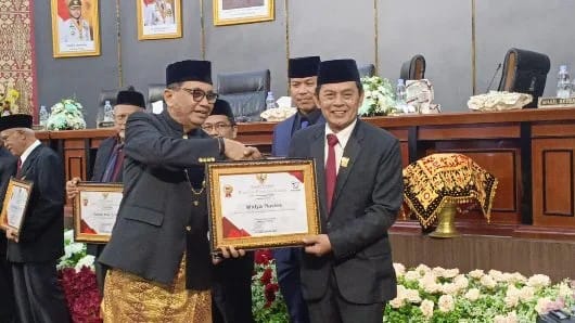 Wakil Ketua DPRD Kota Padang Mastilizal Aye saat menyerahkan piagam penghargaan kepada Ketua PWI Sumbar Widya Navies, Jum’at (07/07/2026).