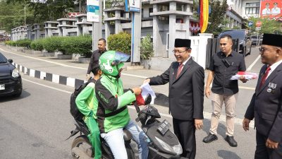 Wali Kota Payakumbuh Zulmaeta saat membagikan bendera merah putih kepada warga, Jum’at (14/08/2026).