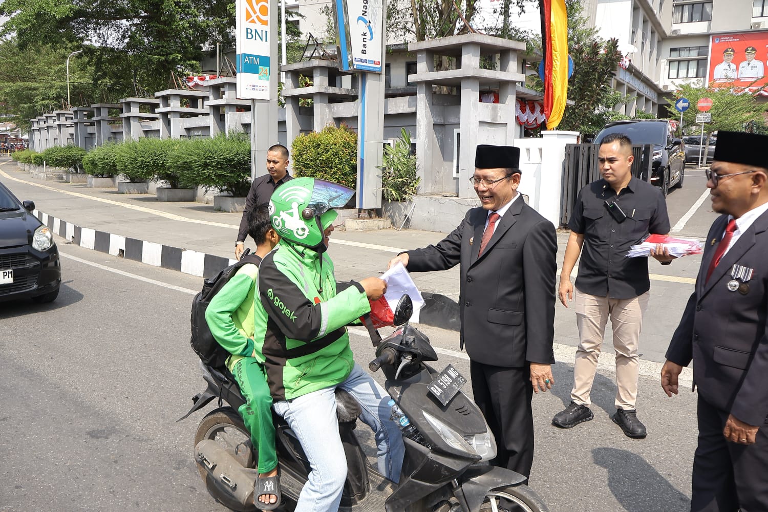 Wali Kota Payakumbuh Zulmaeta saat membagikan bendera merah putih kepada warga, Jum’at (14/08/2026).
