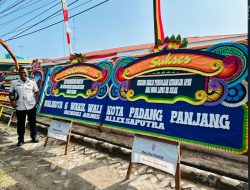 Dedi Suryadi dengan latar belakang karangan bunga Wali Kota dan Wakil Wali Kota Padangpanjang