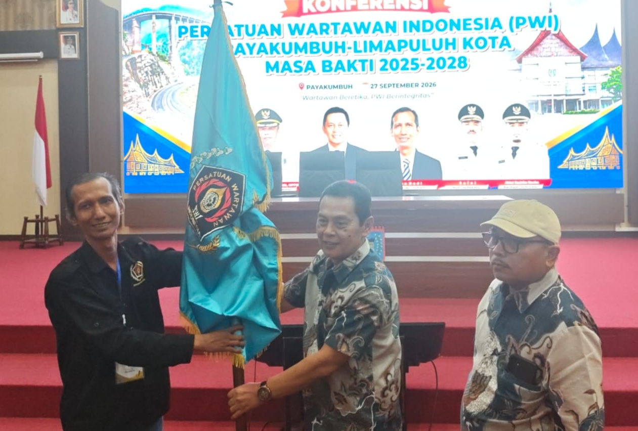 Ketua PWI Paliko terpilih Aspon Dedi menerima Pataka PWI dari Ketua PWI Sumbar Widya Navies didampingi Ketua Bidang Organisasi Sawir Pribadi, Minggu (27/09/2026).