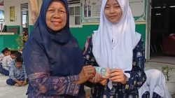 Kepala MTsN 6 Solok Selatan Lili Defita, S.Pd saat memberikan penghargaan kepada siswi berprestasi.