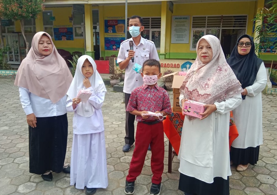 Kepala Sekolah SDN 04 Bariang Rao-rao Asbandi, S.Pd, M.Pd membagikan masker gratis untuk siswa, Kamis (17/09/2026).