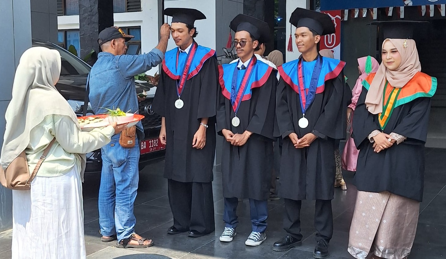 Ketua MAA Sumatera Barat Dr. Sulaiman Juned, S.Sn., M.Sn saat melaksanakan tradisi Peusijuek bagi empat mahasiswa asal Aceh yang mengikuti prosesi wisuda Periode I Tahun Akademik 2026/2027 ISI Padangpanjang di pelataran Rektorat, Selasa (15/09/2026). 