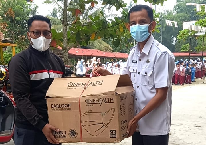 Ketua PGRI Kabupaten Solok Selatan Asbandi, S.Pd, M.Pd saat penyaluran masker kepada sekolah.