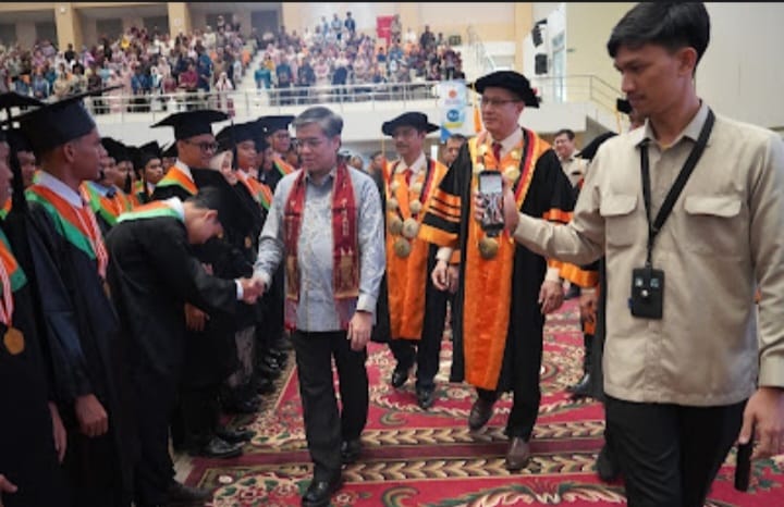 Menteri Ketenagakerjaan Prof. Ir. Yassierli, ST., MT., Ph.D. didampingi Direktur PNP Ir. Revalin Herdianto, ST., M.Sc., Ph.D menyalami wusudawan PNP usai memberikan orasi ilmiah pada Wisuda ke-72 PNP, Sabtu (26/09/2026). 