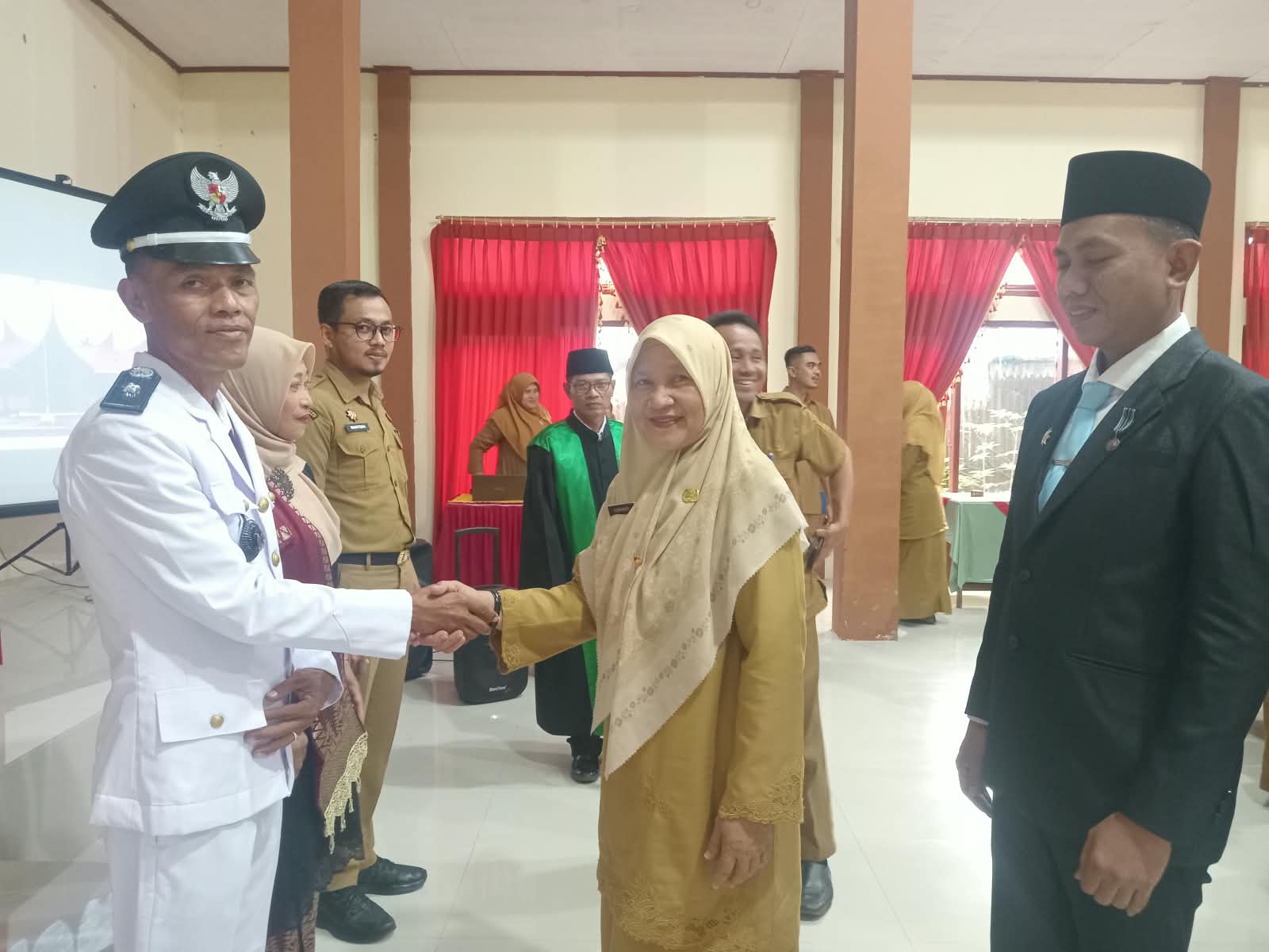 Kepala Dinas Sosial,PMD Kabupaten Solok Selatan drh. Nurhayati di dampingi Camat KPGD Prima Wijaya,S.IP saat memberikan ucapan selamat kepada Syafrianto.