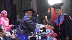 Rektor ISI Padangpanjang Dr. Febri Yulika, S.Ag., M.Hum saat menyalami salah satu lulusan saat Wisuda Program Sarjana Terapan, Sarjan dan Program Magister Periode I Tahun Akademik 2026/2027 di Gedung Pertunjukan Hoeridjah Adam, Selasa (15/09/20269). 