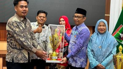 Direktur BUMNag Lubuk Malako,Pj Wali Nagari Lubuk Malako Abdul Reda, Kepala Dinas Sosial PMD Nurhayati saat menerima piala penghargaan BUMNag terbaik Se- Sumatera Barat.  