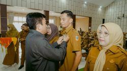 Ketua DPRD Solok Selatan Martius, menyematkan Pin kepada Ketua PGRI Solok Selatan Asbandi, S.Pd., MM pada pembukaan Sosialisasi Anti Korupsi di Aula Sarantau Sasurambi Kantor Bupati Solok Selatan, Senin (19/10/2026). 