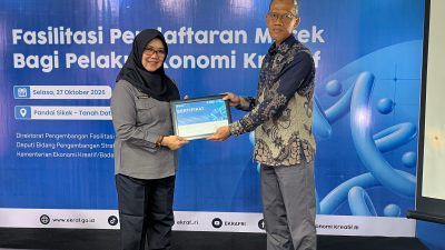 Tenaga Ahli Menteri Bidang Efektivitas dan Anggaran Milik Negara Kemenkraf Muhammad Idris, saat menyerahkan cinderamata kepada Desmaniar, SH., M.Si dari Kanwil Kementrian Hukum Sumbar sebagai narusumber Fasilitasi Pendaftaran Merek Bagi Pelaku Ekonomi Kreatif di Kantor Wali Nagari Pandai Sikek, Selasa (27/10/2026).