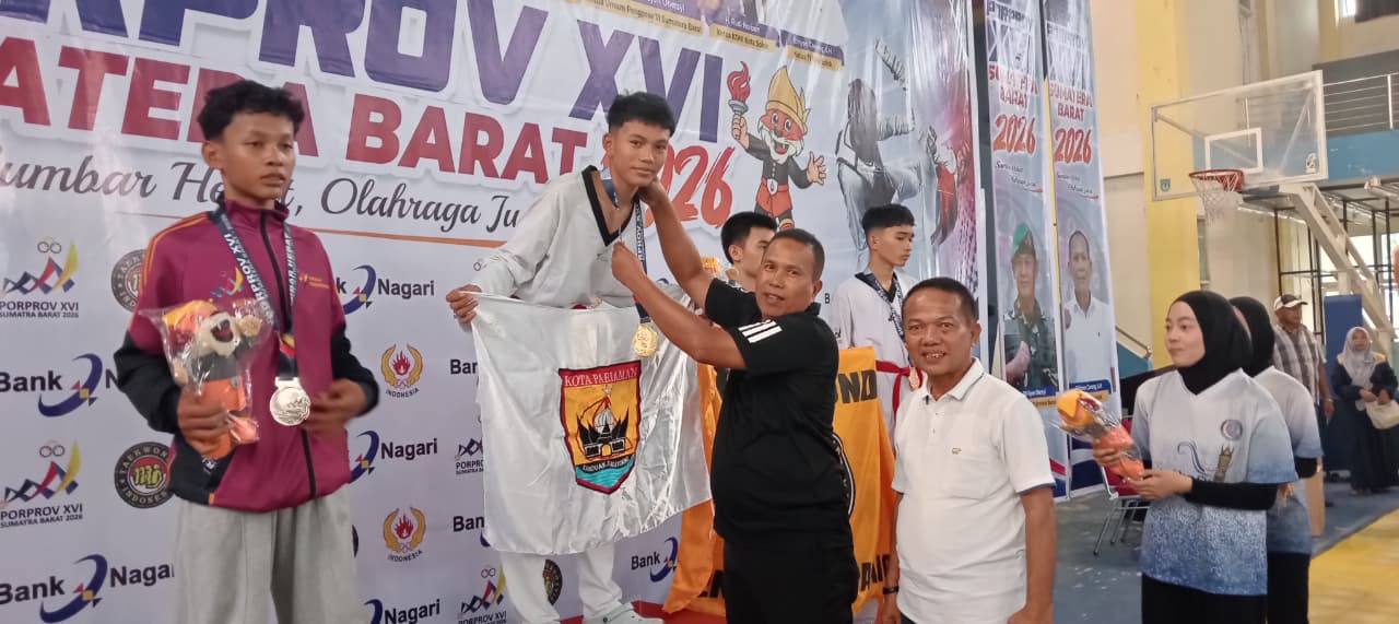 Wakil Wali Kota Pariaman Mulyadi M.AP, didampingi ketua KONI Edison Trd saat menyerahkan medali emas Atlet Taekwondo Kota Pariaman di GOR Alimin Sinapa, Kota Solok.